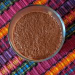 Image shows the top view a vegan cacao mousse in a glass