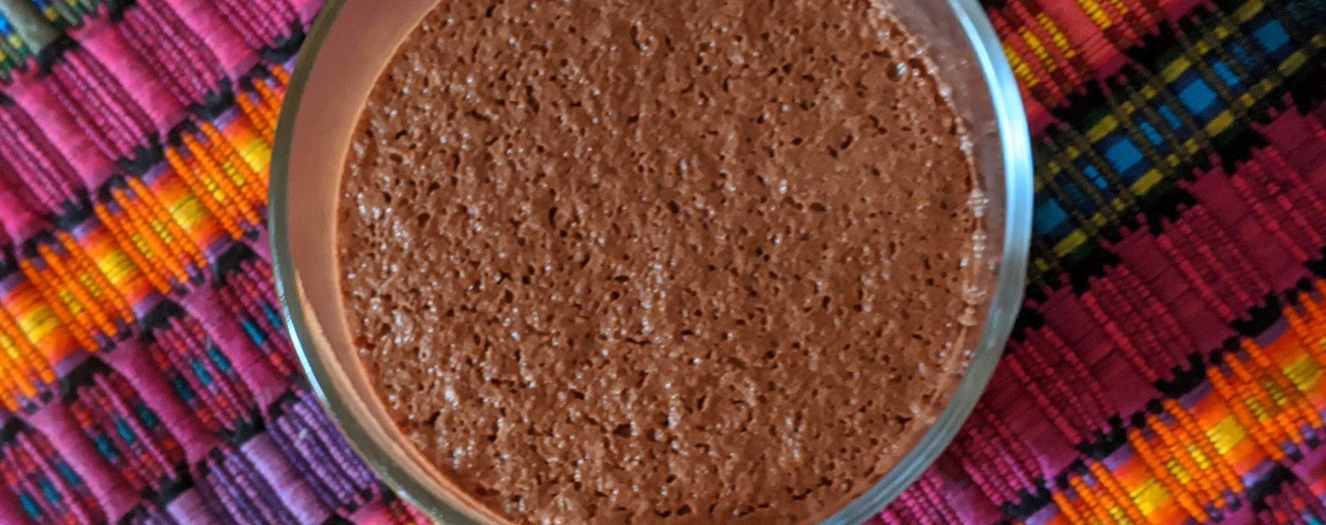 Image shows the top view a vegan cacao mousse in a glass