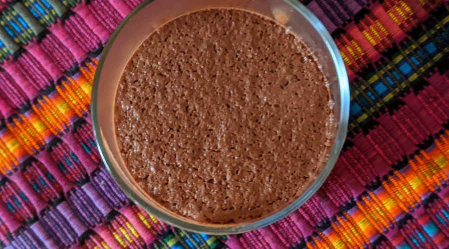 Image shows the top view a vegan cacao mousse in a glass